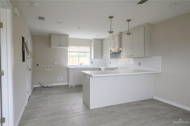 kitchen with kitchen peninsula, sink, and light hardwood / wood-style floors