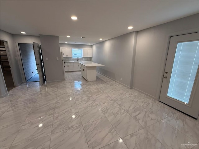 kitchen featuring recessed lighting, white cabinets, light countertops, and marble finish floor