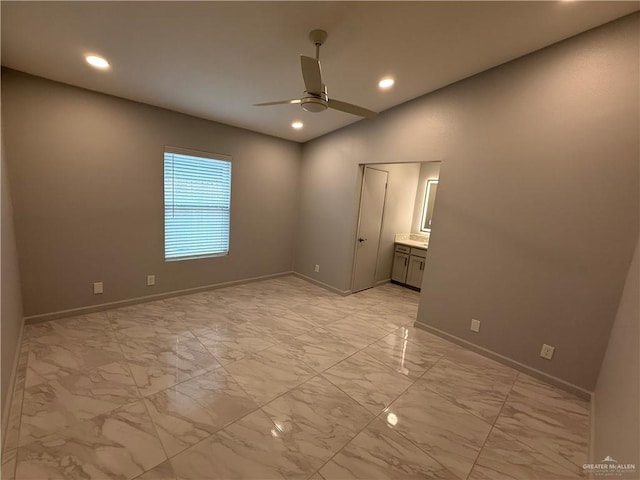 unfurnished bedroom with lofted ceiling, marble finish floor, and baseboards