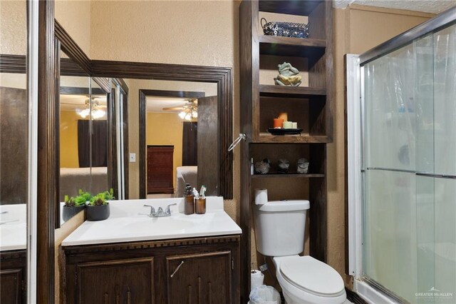 2820 Joan Dr, Edinburg, TX 78541 - full bathroom with vanity, a shower stall, toilet, ceiling fan, and a textured wall