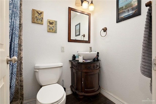 bathroom featuring vanity, hardwood / wood-style flooring, and toilet