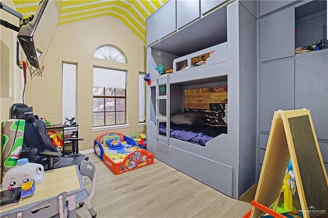 bedroom with hardwood / wood-style floors and lofted ceiling