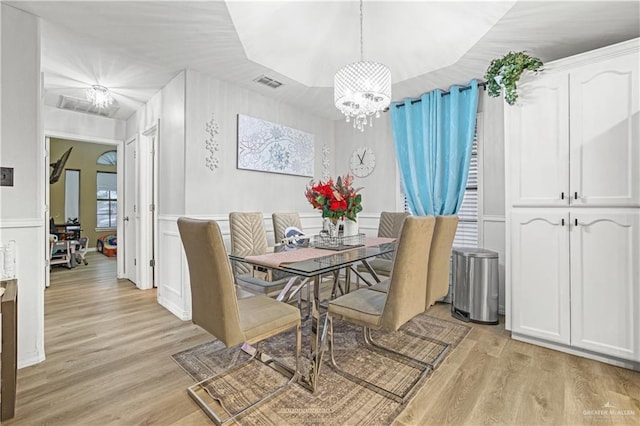 dining space featuring an inviting chandelier and light wood-type flooring