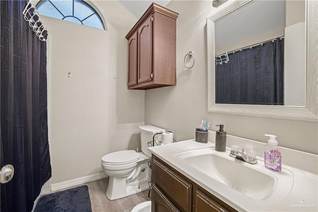 bathroom featuring toilet, vanity, and hardwood / wood-style flooring