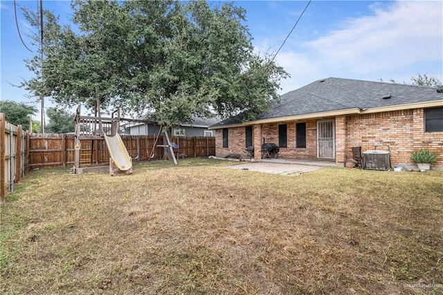 back of property featuring a playground, a patio, central air condition unit, and a lawn