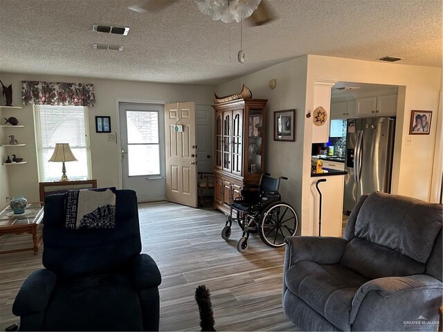 42 E Cherokee Dr, Harlingen, TX 78550 - living area with ceiling fan, light wood finished floors, and a textured ceiling