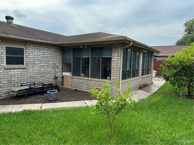 42 E Cherokee Dr, Harlingen, TX 78550 - view of side of property with a sunroom, brick siding, and roof with shingles