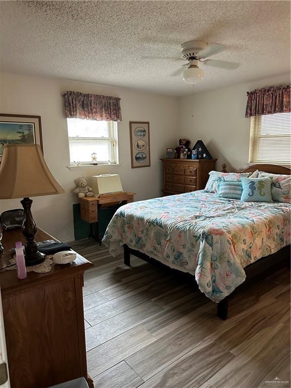 42 E Cherokee Dr, Harlingen, TX 78550 - bedroom with a textured ceiling, wood finished floors, and a ceiling fan