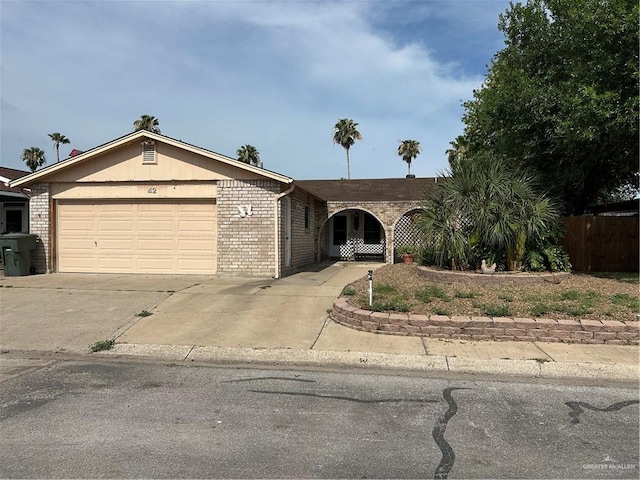 42 E Cherokee Dr, Harlingen, TX 78550 - ranch-style home featuring an attached garage, concrete driveway, and brick siding