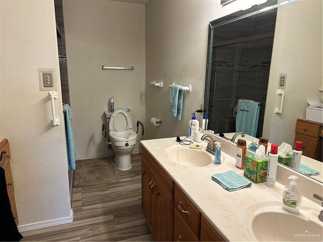 42 E Cherokee Dr, Harlingen, TX 78550 - full bathroom featuring double vanity, toilet, a stall shower, baseboards, and a textured wall