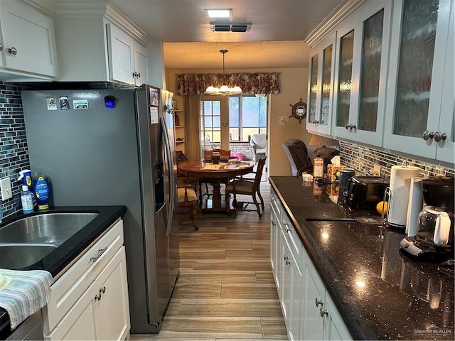 42 E Cherokee Dr, Harlingen, TX 78550 - kitchen featuring a chandelier, light wood-style flooring, tasteful backsplash, and stainless steel fridge with ice dispenser