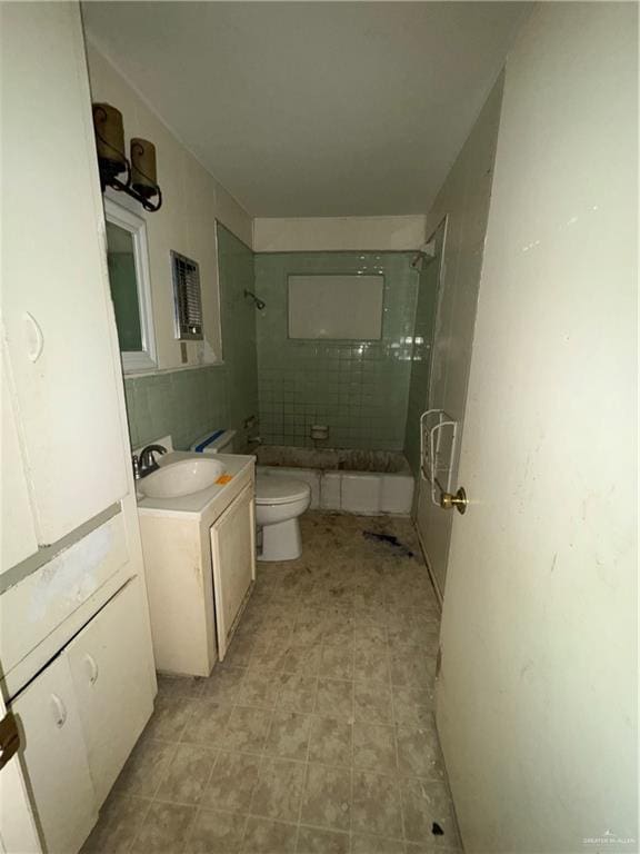 full bathroom featuring vanity, toilet, and tiled shower / bath