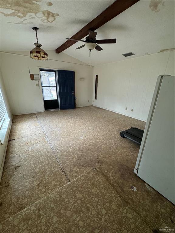 unfurnished room featuring vaulted ceiling with beams and ceiling fan