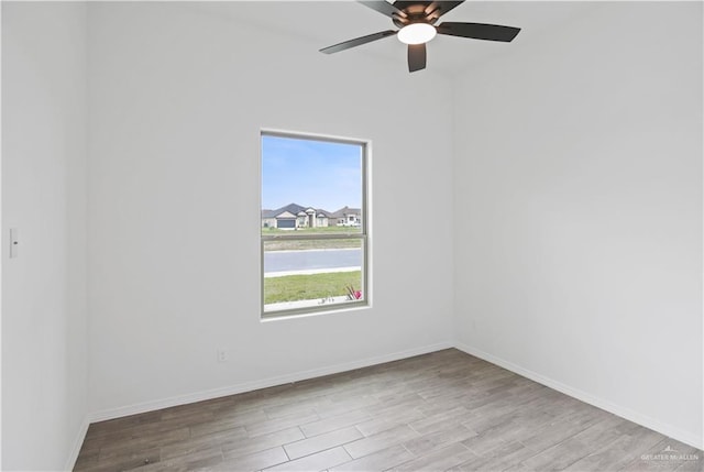 empty room with a ceiling fan, baseboards, and wood finished floors