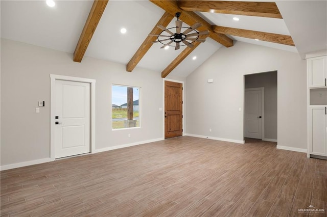 unfurnished living room featuring ceiling fan, light hardwood / wood-style floors, and beam ceiling