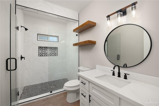 bathroom featuring hardwood / wood-style flooring, vanity, toilet, and a shower with shower door