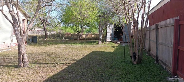 view of yard featuring a fenced backyard, an outdoor structure, and a shed