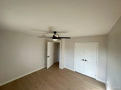 unfurnished bedroom featuring ceiling fan, light hardwood / wood-style flooring, and a closet