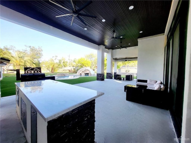 view of patio / terrace with a bar, a pool, and ceiling fan