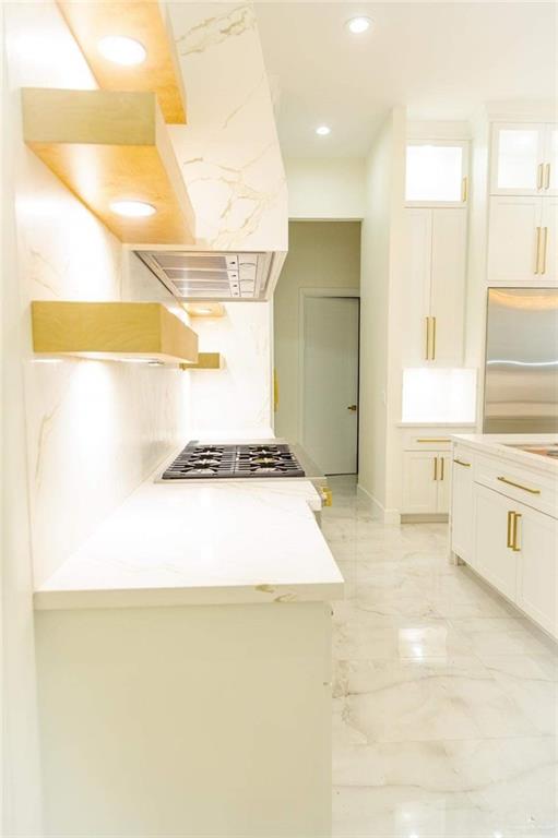 kitchen featuring white cabinetry, light stone countertops, and appliances with stainless steel finishes