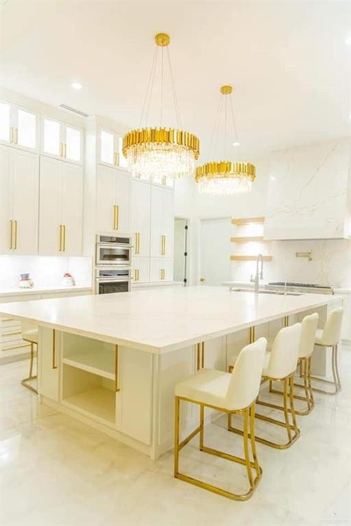 kitchen with white cabinets, hanging light fixtures, and a large island