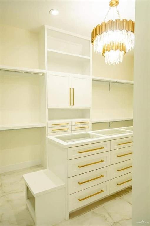 spacious closet featuring an inviting chandelier