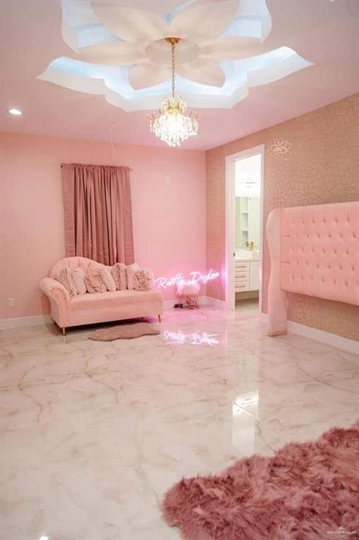 bedroom featuring ensuite bathroom and ceiling fan with notable chandelier