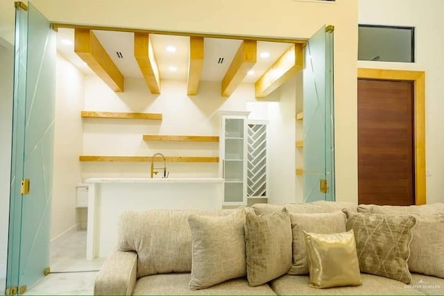 living room featuring beam ceiling and sink