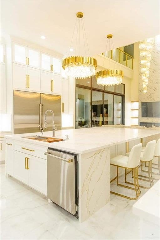 kitchen with hanging light fixtures, white cabinets, stainless steel appliances, and a kitchen island