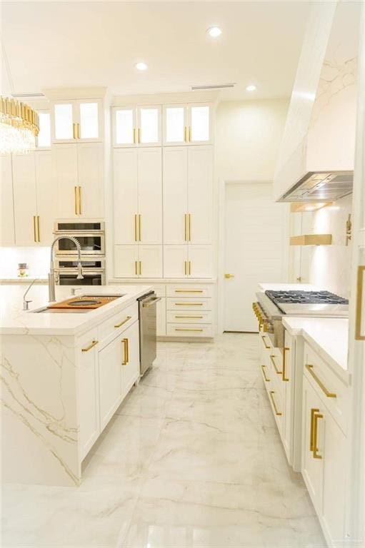 kitchen with premium range hood, a kitchen island with sink, white cabinets, and stainless steel appliances