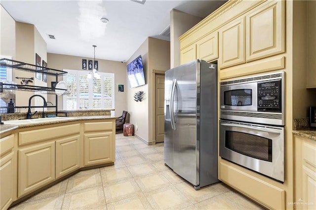 4004 Persimmon Dr, Palmhurst, TX 78573 - kitchen with appliances with stainless steel finishes, cream cabinetry, a sink, a chandelier, and pendant lighting
