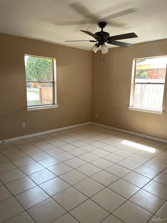 1017 El Recreo Cir, Edinburg, TX 78539 - tiled empty room with plenty of natural light and ceiling fan