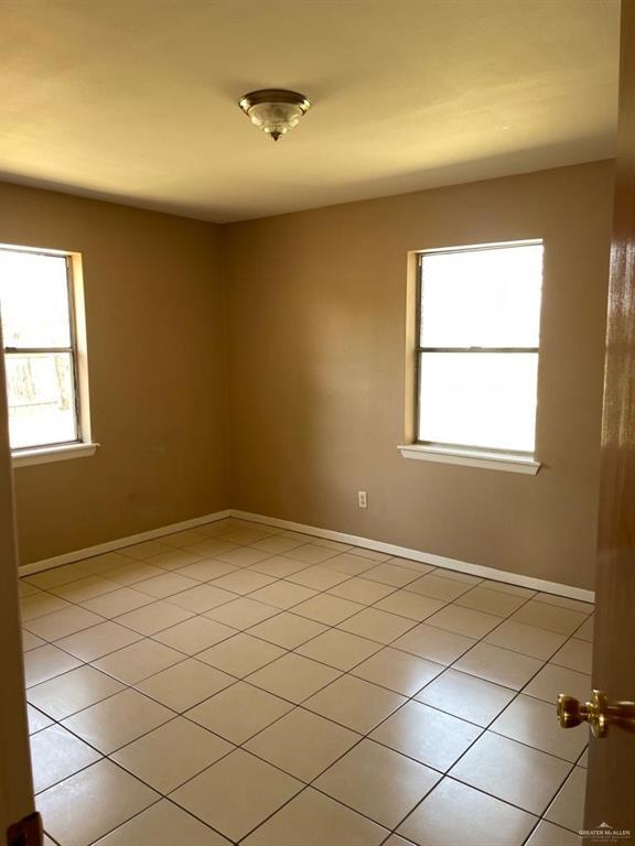 1017 El Recreo Cir, Edinburg, TX 78539 - empty room featuring light tile patterned floors and baseboards