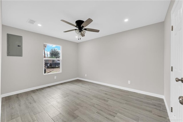 empty room featuring ceiling fan, visible vents, baseboards, light wood-style floors, and electric panel