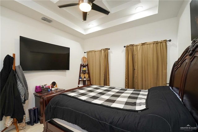 bedroom with a raised ceiling and ceiling fan