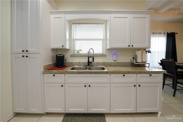 kitchen with white cabinetry, sink, and light tile patterned floors