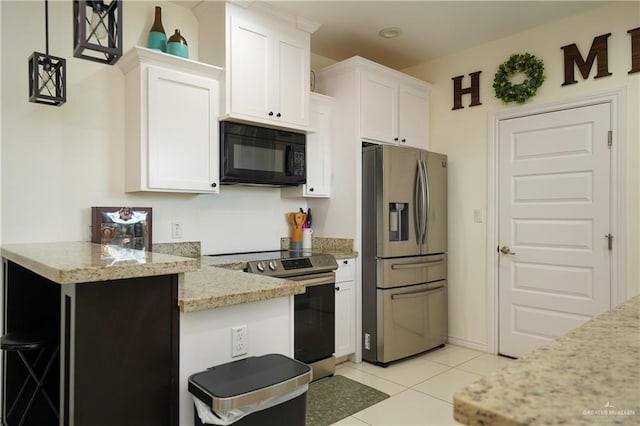 kitchen with stainless steel appliances, light tile patterned floors, white cabinets, and light stone counters