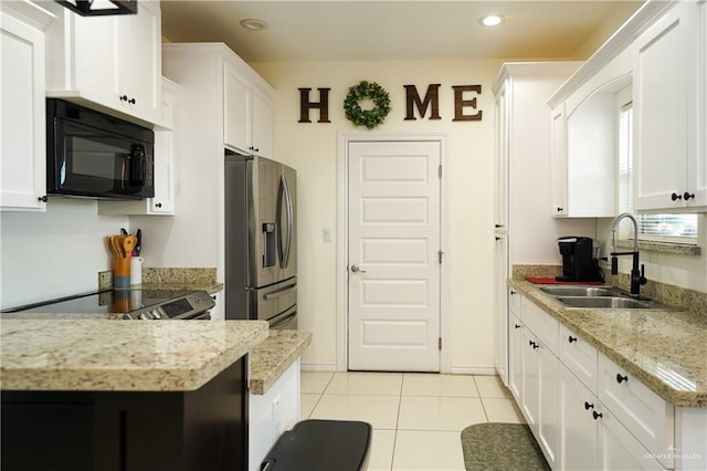 kitchen with white cabinets, sink, and stainless steel fridge