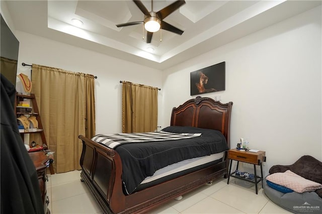 bedroom featuring a tray ceiling, ceiling fan, and light tile patterned flooring