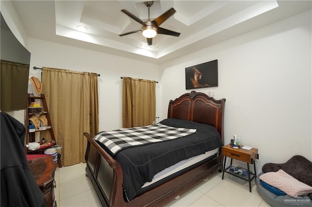 bedroom with ceiling fan, a raised ceiling, and light tile patterned floors