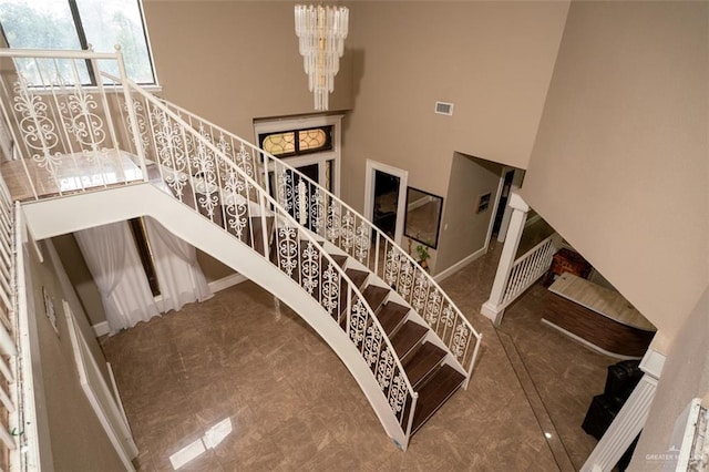 stairs featuring a high ceiling and a notable chandelier