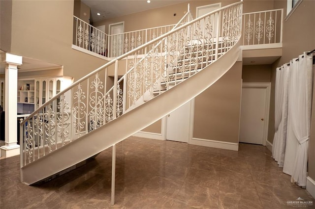 staircase featuring tile patterned flooring and a towering ceiling