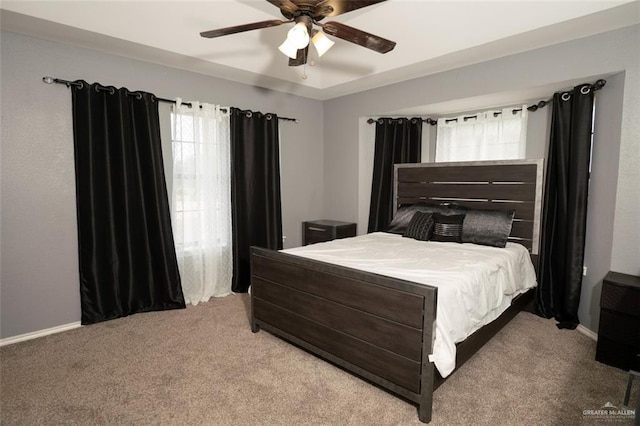 carpeted bedroom with multiple windows and ceiling fan