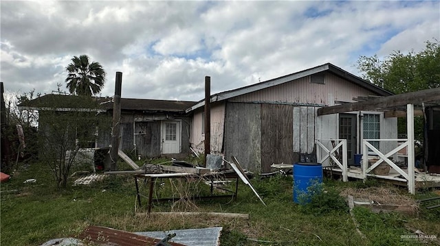 back of house featuring a lawn and a pergola