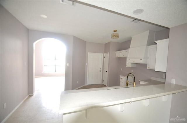 3107 E Laurel St, Hidalgo, TX 78557 - kitchen featuring a sink, baseboards, a kitchen breakfast bar, white cabinets, and light countertops