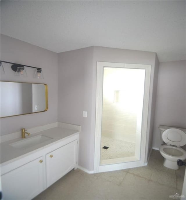 3107 E Laurel St, Hidalgo, TX 78557 - full bathroom featuring toilet, vanity, baseboards, and a walk in shower
