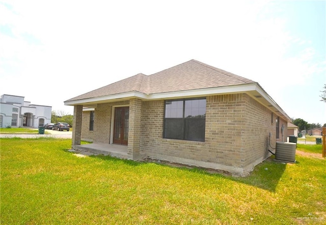 3107 E Laurel St, Hidalgo, TX 78557 - rear view of house featuring brick siding, a lawn, central air condition unit, and a patio