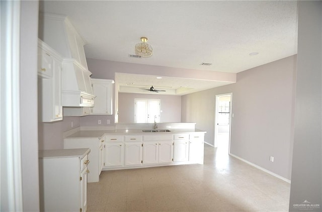 3107 E Laurel St, Hidalgo, TX 78557 - kitchen featuring a sink, white cabinetry, a ceiling fan, and a peninsula