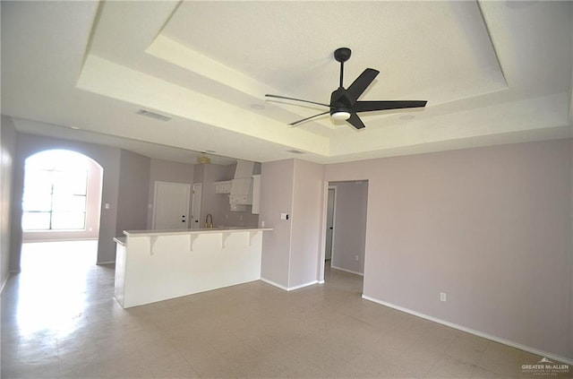 3107 E Laurel St, Hidalgo, TX 78557 - unfurnished living room with a raised ceiling, ceiling fan, arched walkways, baseboards, and tile patterned floors