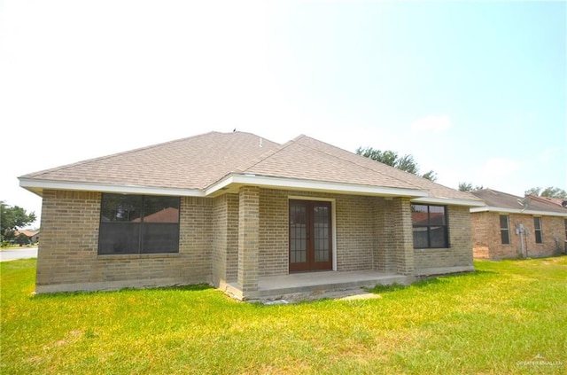 3107 E Laurel St, Hidalgo, TX 78557 - back of property with french doors, brick siding, a yard, and roof with shingles